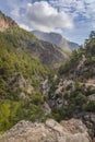 View of mountains, trees, river, sky and stony road Royalty Free Stock Photo