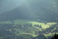 View of the mountains and valleys with houses and meadows, green meadows, hills, houses scattered on the hills, forests and conife