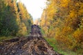 A view of a muddy autumn road with hunters on quads in the background