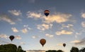 View of Multiple Multi Colored Hot Air Balloons Floating in a Beautiful Morning Blue Sky With Thin Clouds