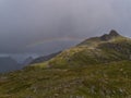 View of Munkebu peak on MoskenesÃÂ¸y, Lofoten, Norway, Scandinavia with green meadows, mountains and colorful rainbow.