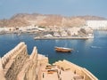 View from Mutrah Fort on the entrance to the Mutrah port in Muscat with a traditional Omani boat Dhow and in the background the Royalty Free Stock Photo
