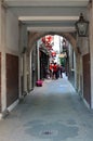 View into a narrow alley in London with people who stay in front of a pub