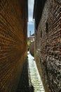 View on narrow alley in medieval belgian village with old brick stone walls on both sides, cobblestone street - Lier Begijnhof, Royalty Free Stock Photo