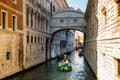 View of narrow canal with motor boat and gondolas in Venice