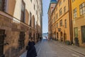 View of a narrow cobblestone tourist alley in Gamlastan, Stockholm, leading to the river waterfront.