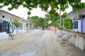 View of narrow street in a poor local village on Maldives, Dhangethi Island. White sand and grey walls