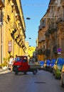 25.08.2018. View of a narrow street with red vintage Ape Piaggio car, old buildings and facades in the historical city of Agrigent