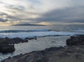 View of the natural sea rock pool on the Tenerife coast near Alcala with vawes crushing against concrete wall and black