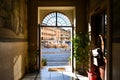 View of the Neptune Fountain with cafes behind from inside a doorway of a medieval building on the Piazza Navona in Rome, Italy