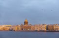 View of the Neva river embankment in St. Petersburg at sunset, buildings, dome of St. Isaac`s Cathedral, birds in the sky Royalty Free Stock Photo