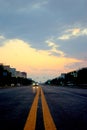 View of a new asphalt road with yellow markings closeup and sunset sky in the background. Royalty Free Stock Photo