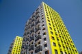 View of the new beautiful apartment building of yellow-green color with orange inserts, hinged glazed balconies.