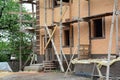 A view of a new brick house under construction with scaffolding,  uninstalled windows and unfinished porch. Clean construction Royalty Free Stock Photo