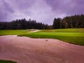 View of a nice golf course with a bunker and a nice green Royalty Free Stock Photo