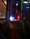 View of the night city street from the window of the trolleybus, yaki lights are reflected on wet glass windows Royalty Free Stock Photo