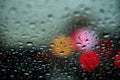 View of the night city through the window on a rainy night, raindrops fall on the windshield of the car. Concept life of