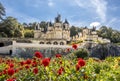 View no the beautiful medieval castle on sunny day with trees and flowers on the foreground, France.