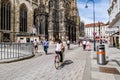 View of the north side of Stephansplatz and St. Stephen\'s Cathedral. A woman cycles through the square.