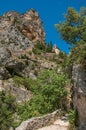 View of the Notre-Dame de Beauvoir church amidst cliffs and rock stairway.