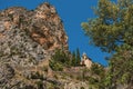 View of the Notre-Dame de Beauvoir church amidst cliffs and rock stairway.