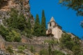 View of the Notre-Dame de Beauvoir church amidst cliffs and rock stairway.