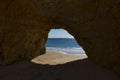 View of the Ocean from a cave in the scenic beach Praia dos Tres Irmaos in Alvor, Algarve, Portugal Royalty Free Stock Photo