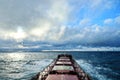 View of the ocean and sky through raindrops on the glass of a ship`s porthole.