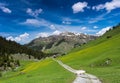 Odd block of snow obstructing a gravel road in a gorgeous mountain landscape near Klosters on a summer day Royalty Free Stock Photo