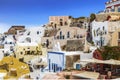 View of Oia city with white buildings, tourists, cafes and shops. Santorini