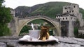 The view of Old bridge in Mostar in the background - in focus. Bosnian coffee in with a turkish delight - out of focus.