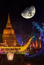 A view of an old Buddhist stupa illuminated in golden light with a huge moon Royalty Free Stock Photo