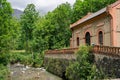View of an old building on the riverbank in the greenery