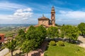 Old catholic church among green trees under beautiful sky in Piedmont, Italy. Royalty Free Stock Photo