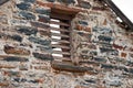 WOODEN SHUTTER VENT ON A STONE AND MORTAR ROOFLESS BUILDING