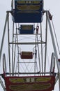 The empty chairs on the old ferris wheel.