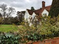 A view of an old English farmhouse and garden.