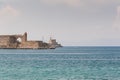 View at old fortification in old port from Akti Sachtouri sea promenade with Delphinia, sculpture of Dolphins. Rhodes, Old Town,