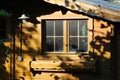 View on old german wooden garden shed with dirty windows in the evening sun and shadows of plants in the garden - Germany