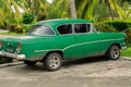 view of old green, customized retro vintage , classic car parked in tropical garden Royalty Free Stock Photo