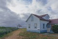 Old house and beacon by the sea under clouds in Discovery Park of Seattle, USA Royalty Free Stock Photo