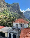 A view of an old house with the steep cliffs of the Valley of the Nuns on Madeira