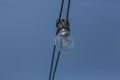 View of an old incandescent lamp, wired outside on the street with blue sky background