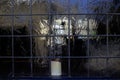View into old leadlight windows with lit candle for use as a background texture Royalty Free Stock Photo