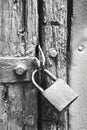 BLACK & WHITE IMAGE OF OLD  PADLOCK ON A WOODEN DOOR WITH FLAKING PAINT Royalty Free Stock Photo