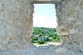 View from old ruined window in stone wall of summer town Royalty Free Stock Photo