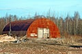 View of an old, rusty, abandoned hangar. An image of decrepitude or a natural disaster Royalty Free Stock Photo
