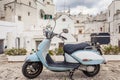 View of the old town of Martina Franca. Classic blue moped on the background of an anient buildings.