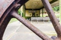 View of the old train station Atenas, through the spokes of an old rusty railway wheel Royalty Free Stock Photo