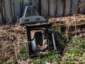 View of old tv broken into pieces thrown out in nature near a fence. Discarded electronics Royalty Free Stock Photo